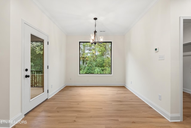 unfurnished dining area featuring ornamental molding, a chandelier, light hardwood / wood-style flooring, and a wealth of natural light