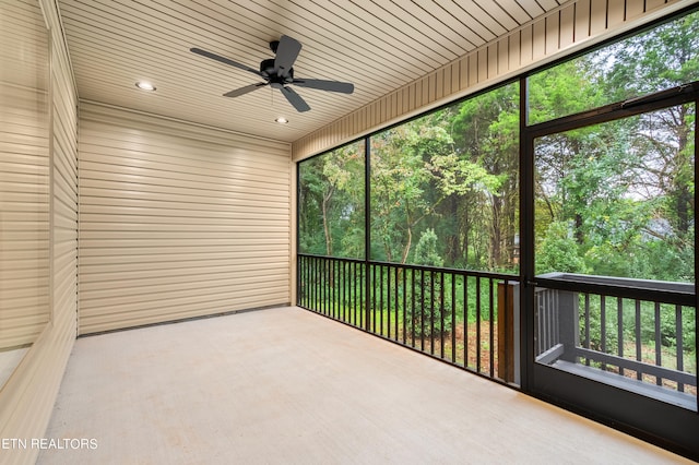 unfurnished sunroom featuring ceiling fan, plenty of natural light, and wooden ceiling