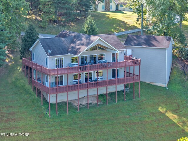 back of property with a balcony and a yard