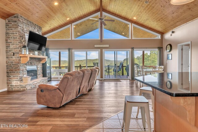 living room featuring a fireplace, ceiling fan, wooden ceiling, and hardwood / wood-style floors