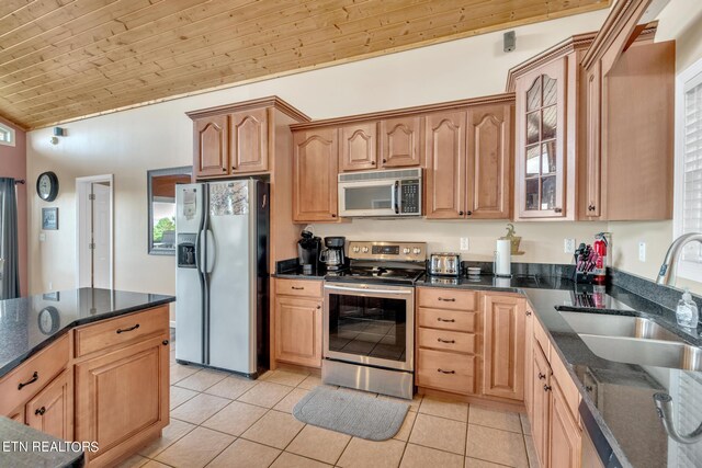 kitchen featuring appliances with stainless steel finishes, wood ceiling, light tile patterned floors, lofted ceiling, and sink