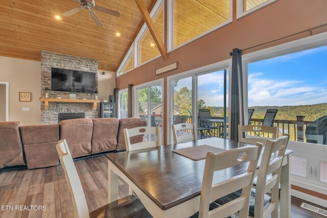 dining space with wood ceiling, wood-type flooring, ceiling fan, and a fireplace