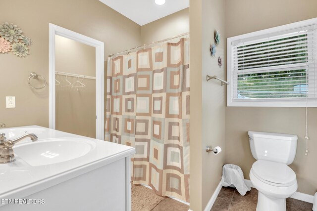 bathroom with curtained shower, vanity, toilet, and tile patterned floors