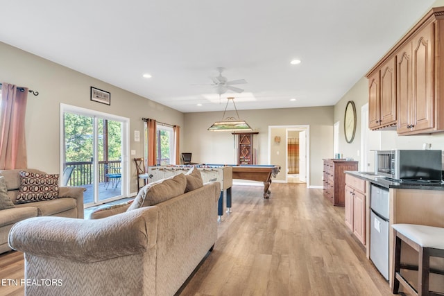 living room featuring ceiling fan, light hardwood / wood-style floors, and billiards