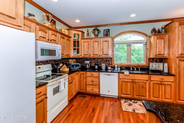 kitchen with dark stone countertops, white appliances, dark hardwood / wood-style flooring, sink, and tasteful backsplash