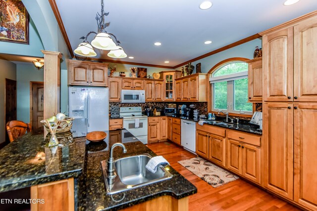 kitchen featuring wood-type flooring, sink, decorative light fixtures, and white appliances