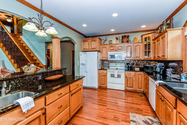 kitchen featuring dark stone countertops, hanging light fixtures, backsplash, light hardwood / wood-style flooring, and white appliances