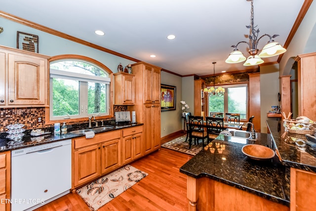 kitchen with dishwasher, pendant lighting, light hardwood / wood-style flooring, a notable chandelier, and sink