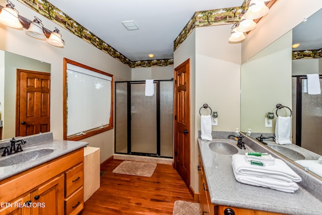 bathroom with vanity, hardwood / wood-style floors, and a shower with shower door