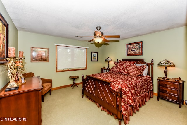 bedroom featuring ceiling fan, light carpet, and a textured ceiling