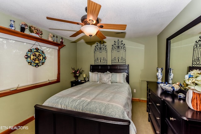 bedroom with a textured ceiling, light colored carpet, and ceiling fan