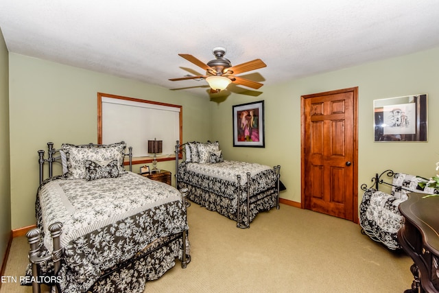 bedroom with a textured ceiling, carpet flooring, and ceiling fan