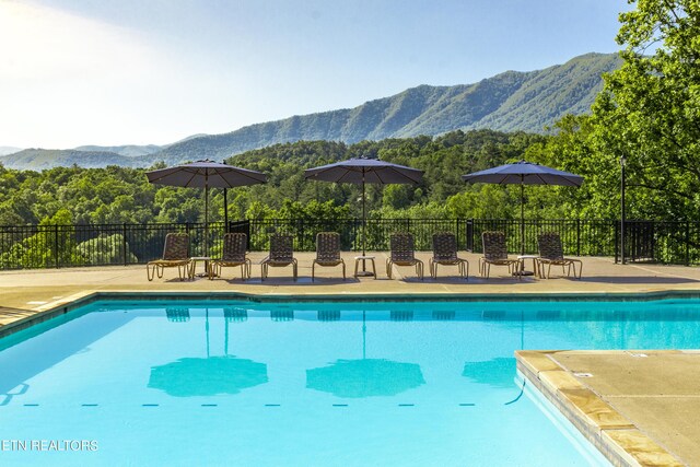 view of swimming pool featuring a mountain view and a patio area