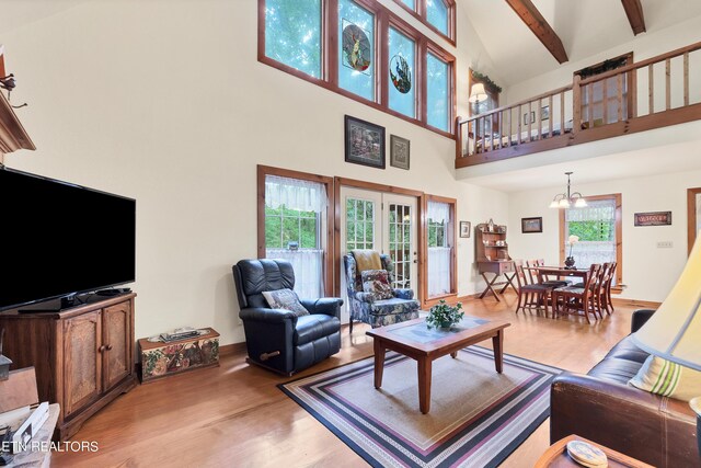 living room featuring a healthy amount of sunlight, beamed ceiling, high vaulted ceiling, and light hardwood / wood-style floors