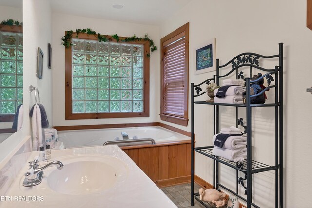 bathroom with a tub and vanity