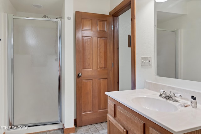 bathroom featuring a shower with door and vanity