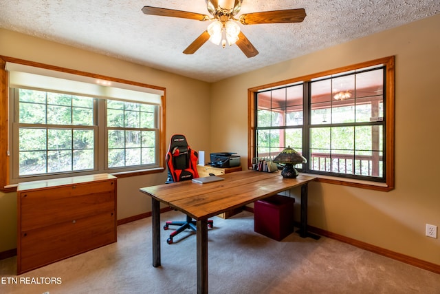 carpeted home office with ceiling fan, a textured ceiling, and a wealth of natural light