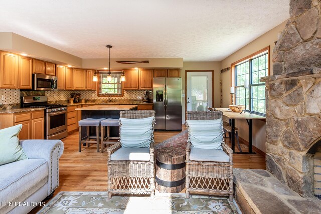 living room with light wood-type flooring, a textured ceiling, and sink