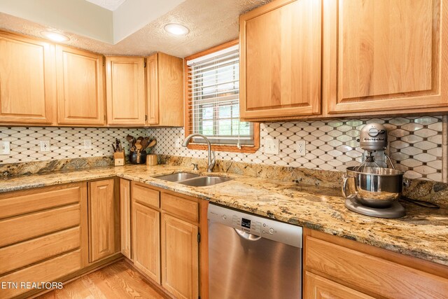 kitchen featuring decorative backsplash, dishwasher, a textured ceiling, and sink