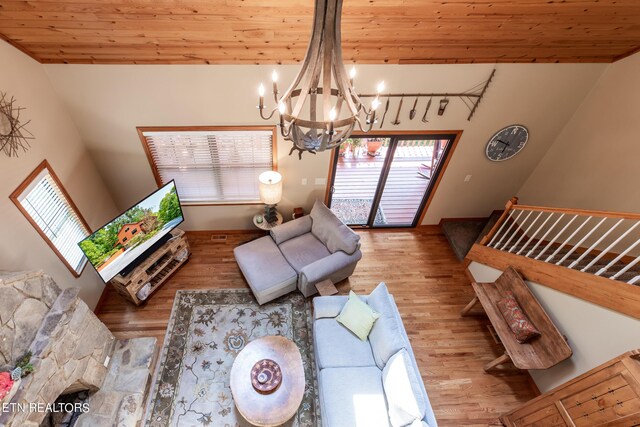 living room with wood-type flooring, a notable chandelier, and wood ceiling