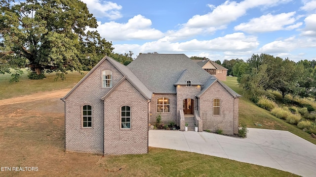 french provincial home featuring a front yard