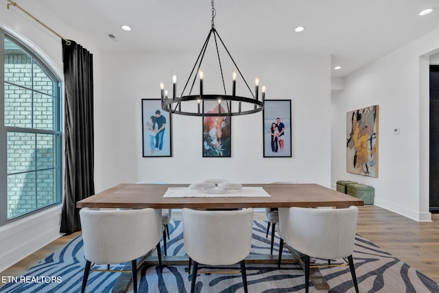 dining room with hardwood / wood-style floors and a chandelier