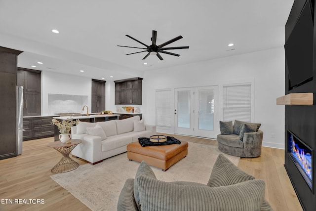 living room featuring ceiling fan and light hardwood / wood-style floors