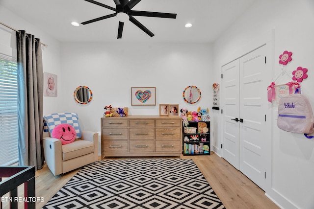 bedroom featuring ceiling fan, light wood-type flooring, and a closet