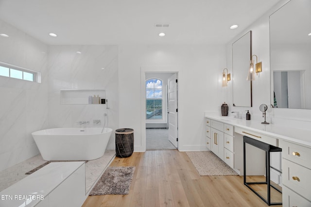 bathroom featuring a washtub, vanity, and hardwood / wood-style flooring