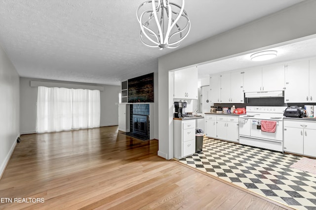 kitchen with white cabinets, light hardwood / wood-style flooring, decorative light fixtures, and electric stove