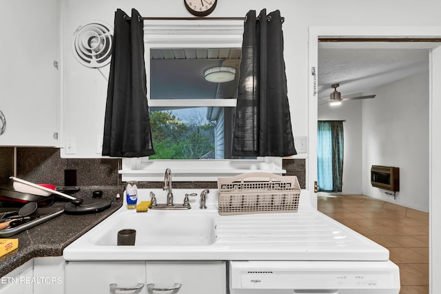 kitchen with sink, white cabinetry, heating unit, decorative backsplash, and tile patterned flooring