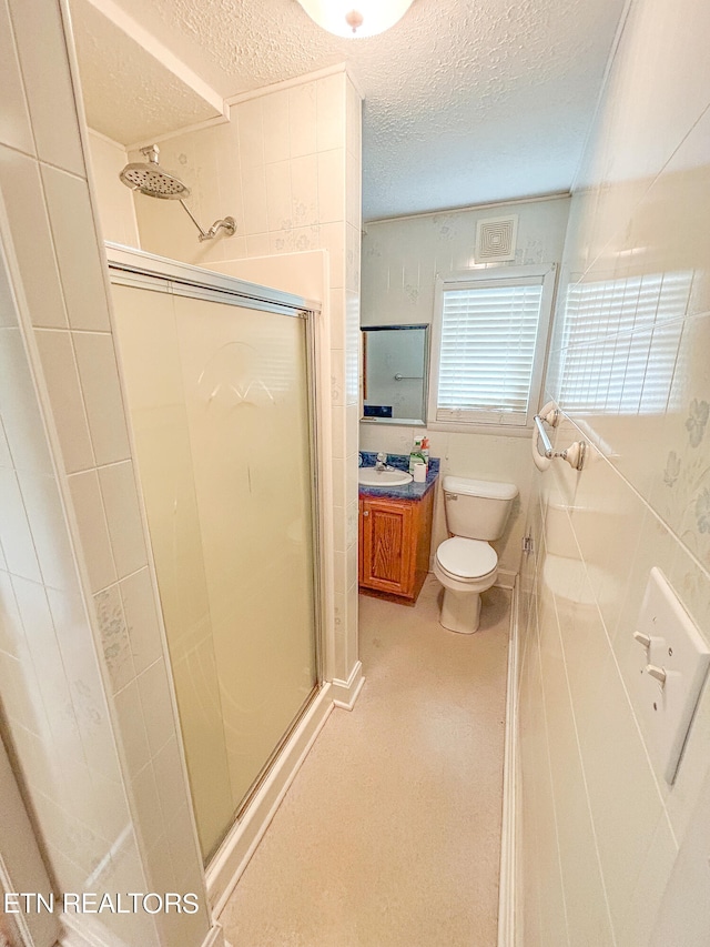 bathroom with vanity, toilet, walk in shower, and a textured ceiling