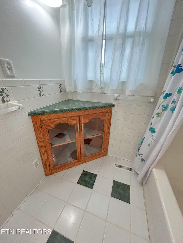 bathroom with tile patterned floors and tile walls