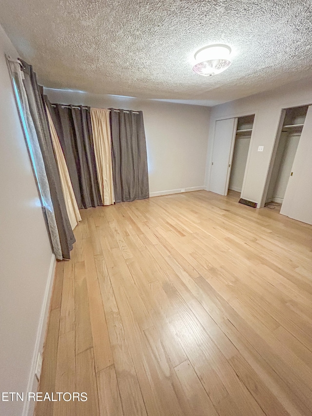 unfurnished bedroom with a textured ceiling and wood-type flooring