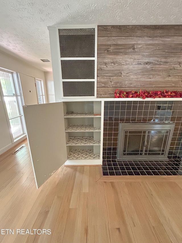 details with a textured ceiling, a fireplace, and wood-type flooring