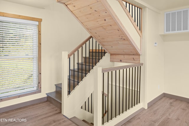 staircase featuring wood ceiling, vaulted ceiling, and hardwood / wood-style flooring