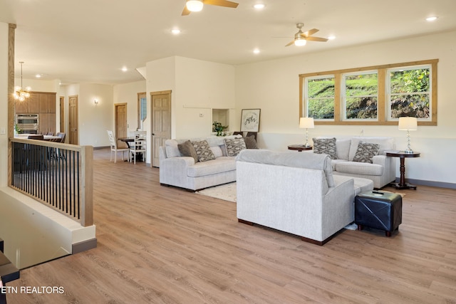 living room with hardwood / wood-style flooring and ceiling fan with notable chandelier