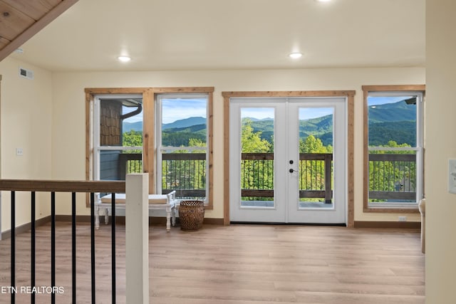 entryway featuring light wood-type flooring, a mountain view, and french doors