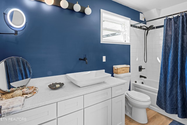 full bathroom with hardwood / wood-style floors, vanity, toilet, and shower / bath combo with shower curtain