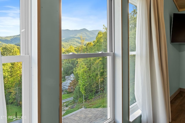 doorway to outside with a wealth of natural light and hardwood / wood-style flooring