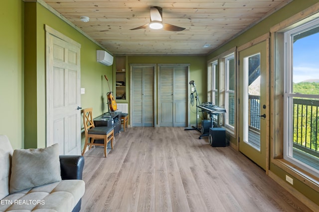 sunroom / solarium featuring ceiling fan, a wall unit AC, wood ceiling, and a wealth of natural light