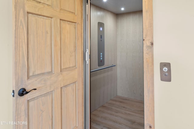 interior details featuring wood-type flooring and elevator