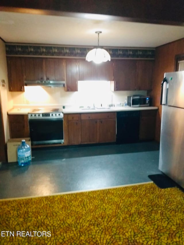 kitchen with appliances with stainless steel finishes, exhaust hood, sink, and hanging light fixtures