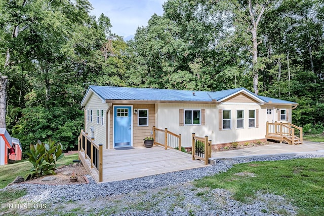 view of front of house featuring a wooden deck and metal roof