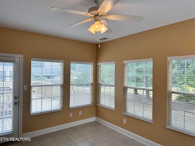 unfurnished sunroom with ceiling fan