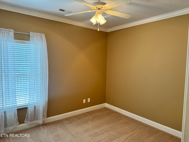 carpeted spare room featuring crown molding and ceiling fan