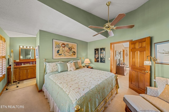 bedroom with light carpet, a textured ceiling, ceiling fan, vaulted ceiling, and ensuite bathroom