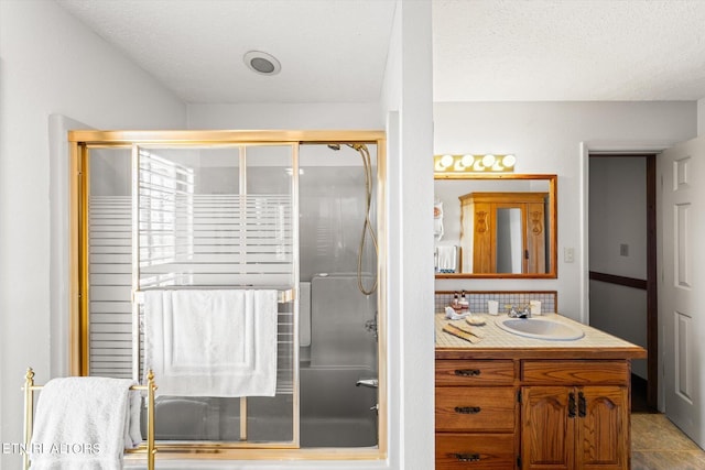 bathroom featuring vanity, a textured ceiling, an enclosed shower, and tile patterned floors