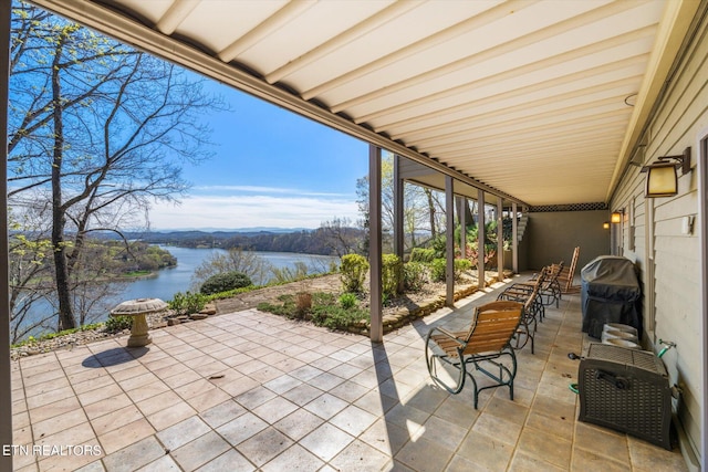 view of patio with a water view and a grill