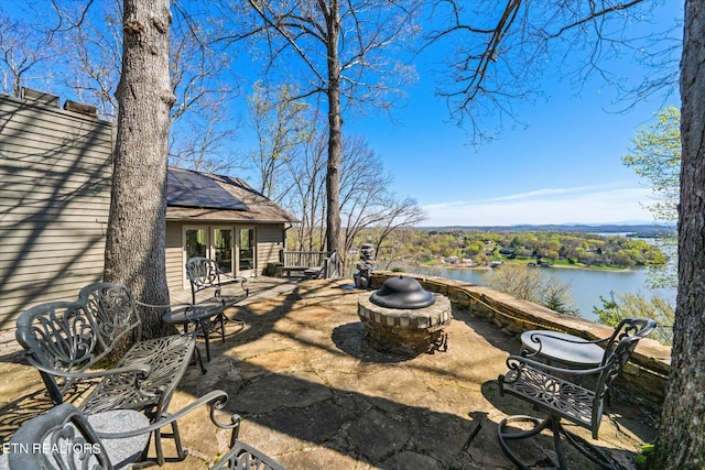 view of patio featuring an outdoor fire pit and a water view